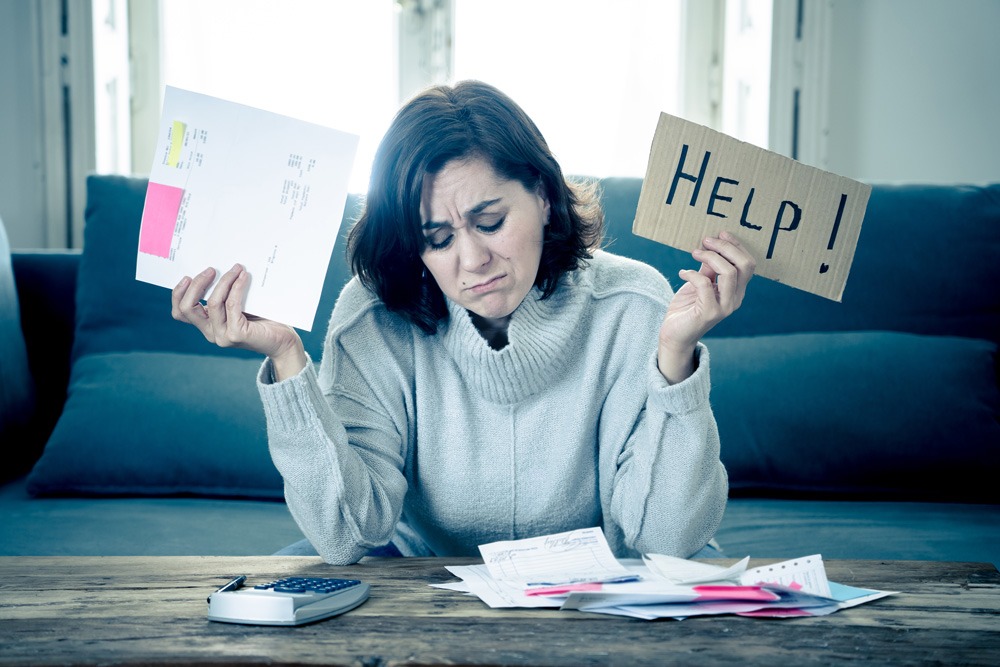 woman holding up a bill and a Help sign