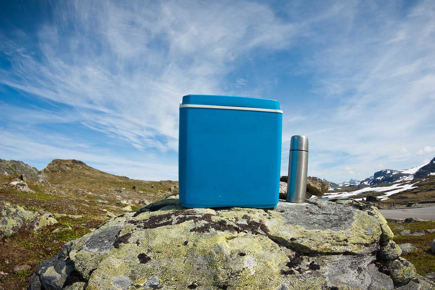 cooler and insulated cup on a rock