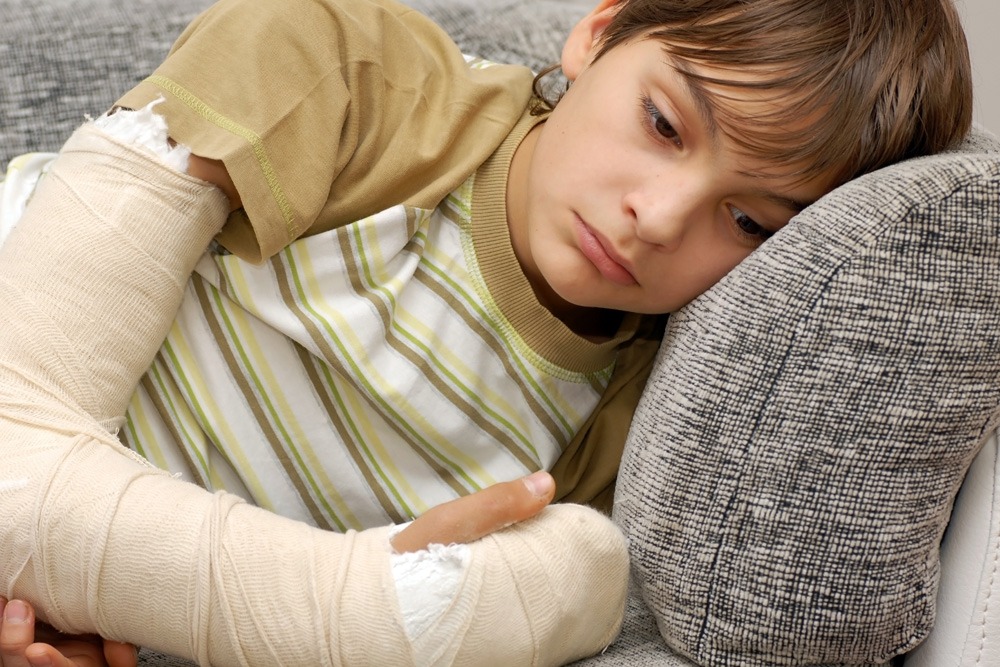 sad child with an arm cast
