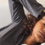 woman touching her forehead checking for a fever